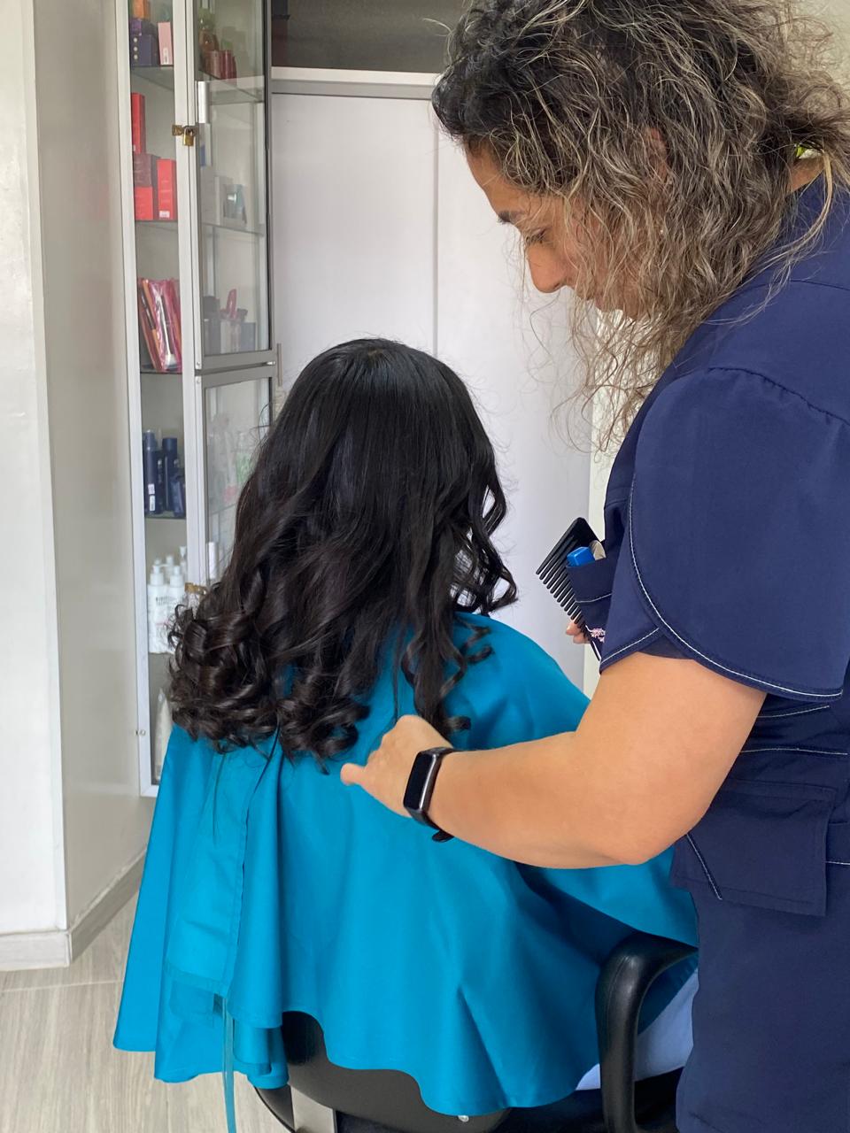 Estilista peinando cabello ondulado